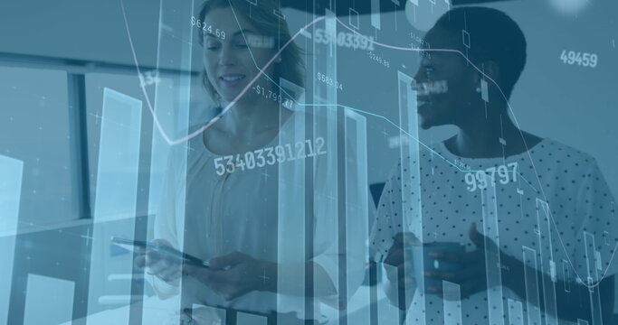 Image of financial graphs and data over diverse female coworkers in office
