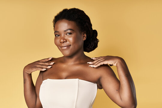 Young woman showcases her beautiful skin and confidence in a bright studio environment