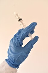 Syringe in gloved hands of a doctor. Medical procedure preparation, symbolizing care, precision, and hygiene.

