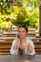 Pretty young girl wearing shorts and a white shirt in the summer park 