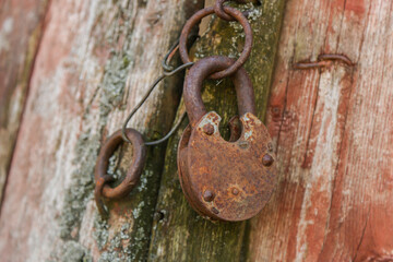 Rusty Lock on Weathered Wooden Door – Concept of Abandonment and Depopulation