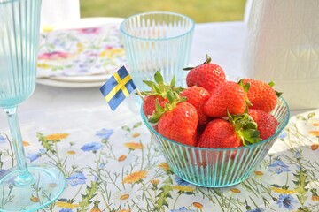 Strawberries with the Swedish flag on the table. Midsommar holiday