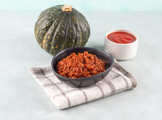 Pumpkin bolognese ragu with soya protein granules on blue background