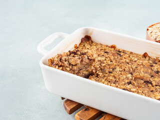 Vegan oatmeal banana cake in white baking pan on turquoise