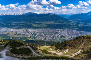 Aerial panorama view of Innsbruck city and Tyrolean alps from Seegruben cable car station in spring on a sunny day, Innsbruck, Austria