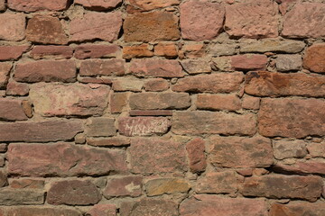 medieval wall made of irregular red stones