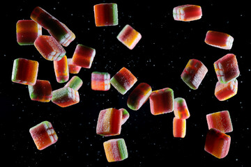 caramelle multicolore che cadono, su sfondo nero