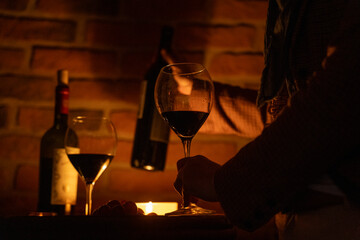 Wine glass and romantic candles at wine cellar covered in old bricks