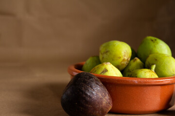 Close-Up of Fresh Green and Purple Figs in a Clay Bowl