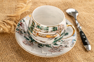 One ceramic  cup with saucer on jute cloth, close-up
