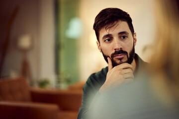 Thoughtful Man Engaged in Conversation in a Modern Cozy Interior
