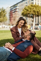 Happy Couple Relaxing on Green Grass in an Urban Park Setting
