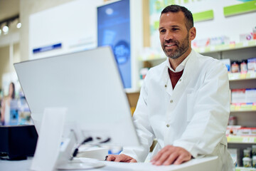 Healthcare Professional at Pharmacy Counter Using Computer for Prescription Management
