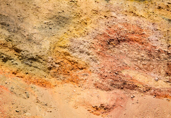 Aged shabby cliff face and divided by huge cracks and layers. Rough stone or rock texture of mountains. Background and copy space for text.Theme geology and mountaineering.Slagheap background.