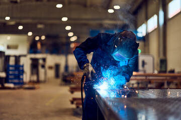 Welder Working with Intense Sparks in a Modern Industrial Workshop