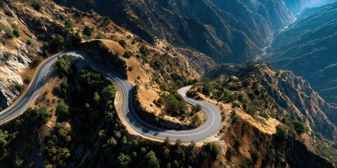 Scenic mountain road curving through golden brown rocky hills and green vegetation
