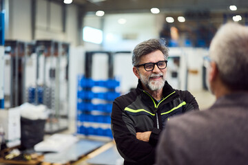 Senior Engineer Discussing Work at a Modern Industrial Manufacturing Facility