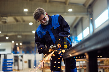 Skilled Worker Grinding Metal in Factory Workshop with Precision and Focus