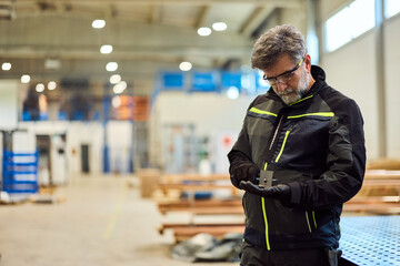 Industrial Worker Examining Metal Component in a Factory Setting with Safety Gear