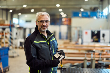 Experienced Craftsman Wearing Safety Gear in a Well-Lit Manufacturing Workshop