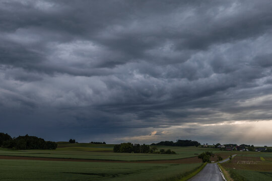 Landschaftsaufnahme mit sch&ouml;nen Regenwolken und gr&uuml;nen Feldern.