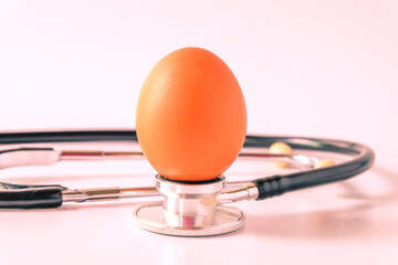 Eggs on stethoscope on white background. Nutrition concept.