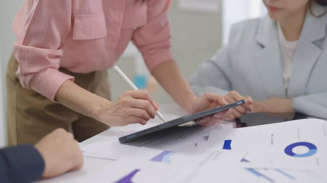 diverse team of business professionals actively engages in a strategic meeting focused on financial planning, goal alignment, and agile execution. With open laptops, financial reports graph chart