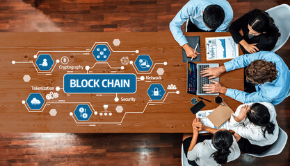 A team of business professionals engaged in a collaborative meeting focused on blockchain...