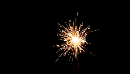 Fototapeta premium Flaming sparkler against a dark, starless night wallpaper. White tone