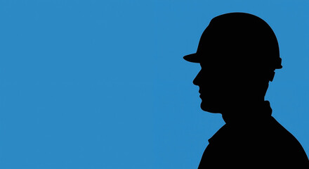 Construction worker silhouette against blue sky. Professional builder in hard hat profile view. Labor and industry concept