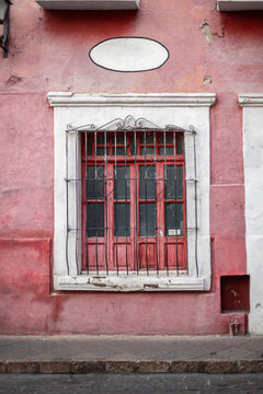 Ventana antigua con guardapolvo color rosa avejentado, Colonial queretano. Herreria mexicana. Rejas curvadas.
