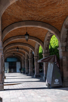 Pasillo portales con arcos de piedra cantera rosa. 	
Arquitectura mexicana antigua y faroles negros.