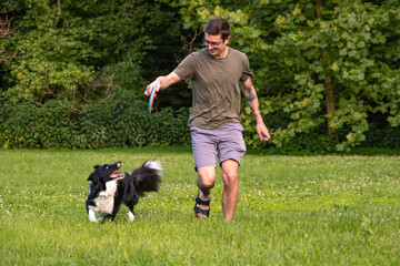 Man playing frisbee with his Border Collie dog