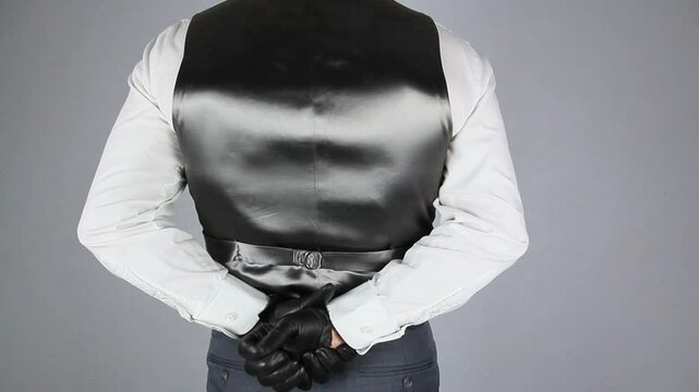 Vintage Ruffian in Waistcoat and Leather Gloves Standing With His Hands Behind His Back