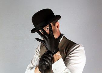 Vintage Ruffian or Back Alley Brawler Pulling on Leather Gloves in Threatening Manner. Threat of Danger or Violence.