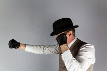 Vintage Ruffian or Back Alley Brawler in Bowler Hat and Leather Gloves Standing in Fighting Stance. Threat of Violence or Danger.