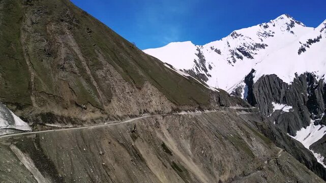 Dramatic drone sweep of Zojila Pass with sharp turns and steep drops.