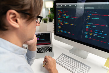 IT developer looking at online software development information on pc align working laptop with...