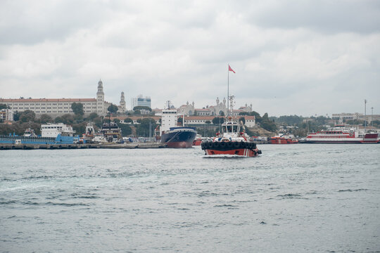 Bosphorus Strait showcasing tugboats and cargo ships under a cloudy sky during daytime
