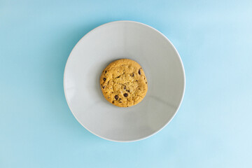 A cookie sits on a white plate