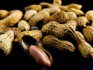 close up dried peanuts on a dark background.