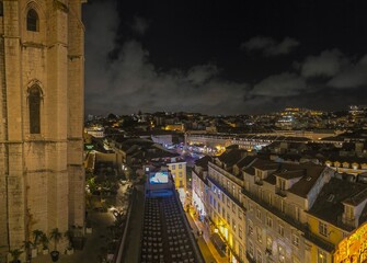 Night panoramic view of the bright Alfama district in Lisbon with a fragment of the walls of the Carmelite Monastery