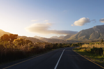 Sunset Country Road Leading to Distant Mountains on the Horizon