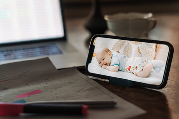 Modern smart parenting concept for working mom. Smartphone baby tracker app for baby monitoring....
