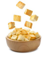 Delicious crispy croutons falling into bowl on white background