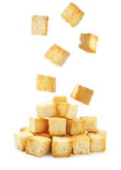Delicious crispy croutons falling onto pile on white background