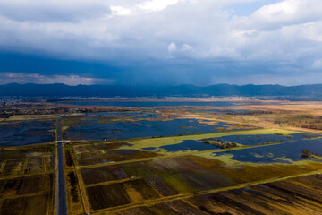 Paisaje natural captado desde un dron, donde se aprecia árboles, agua, manglares, vegetación posiblemente en una zona de humedales o laguna. La escena está bañada por una cálida luz 