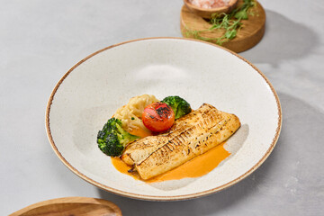 Charcoal fish fillet with cod, vegetables, and bisque sauce, bright lighting, minimalistic plating