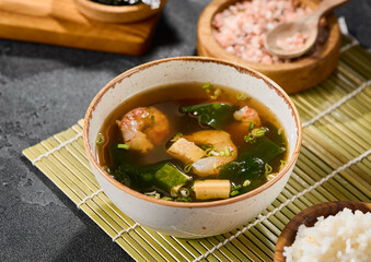 Miso soup with shrimp in natural light, minimalistic composition, fresh ingredients and vibrant textures