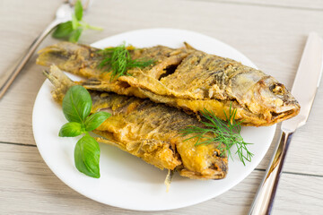 Homemade dish - golden crucian carp on a plate with spices